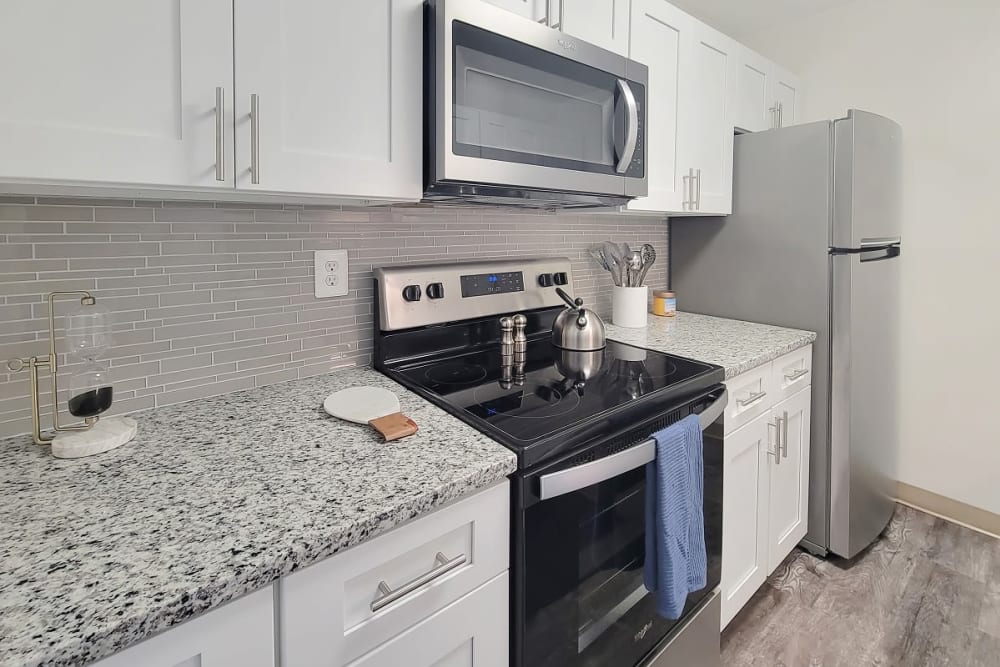 Kitchen with white cabinets, granite countertops, and stainless steel appliances