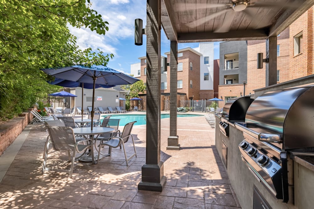 Covered outdoor seating area with grill at Marq Inverness in Englewood, Colorado