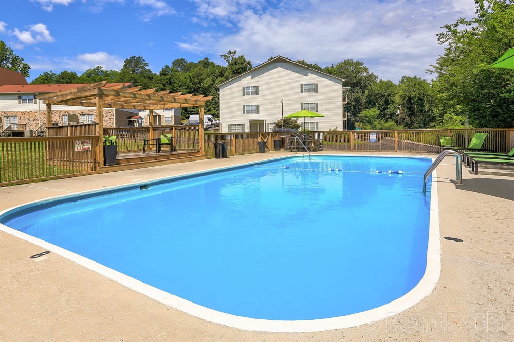 Swimming pool with lounge seating at Country Oaks Apartments in Hixson, Tennessee