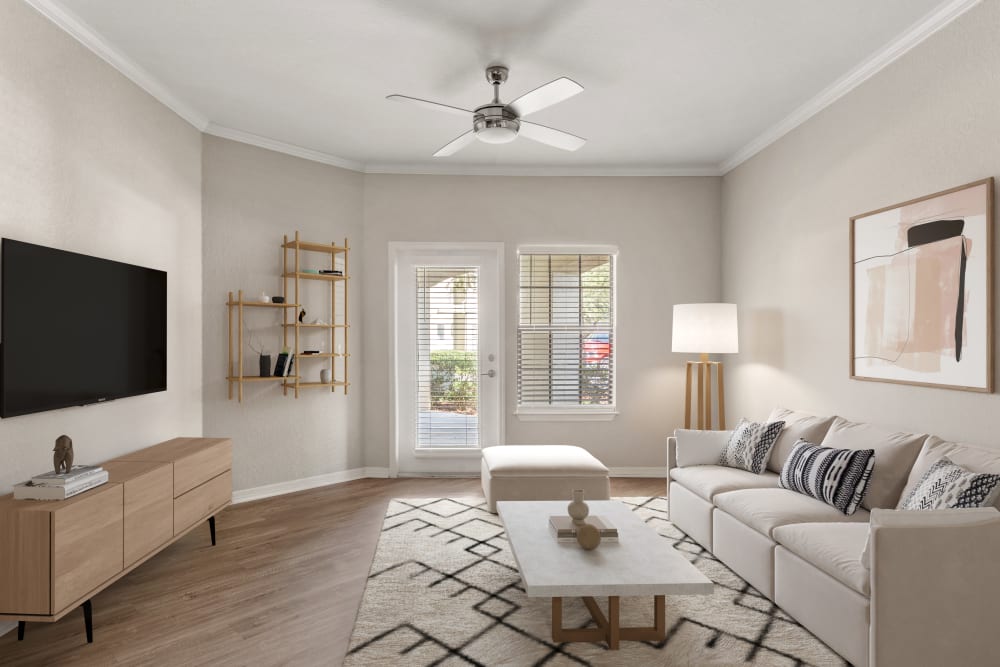 Hardwood flooring and a ceiling fan in the open-concept living area of a model home at Mirador & Stovall at River City in Jacksonville, Florida