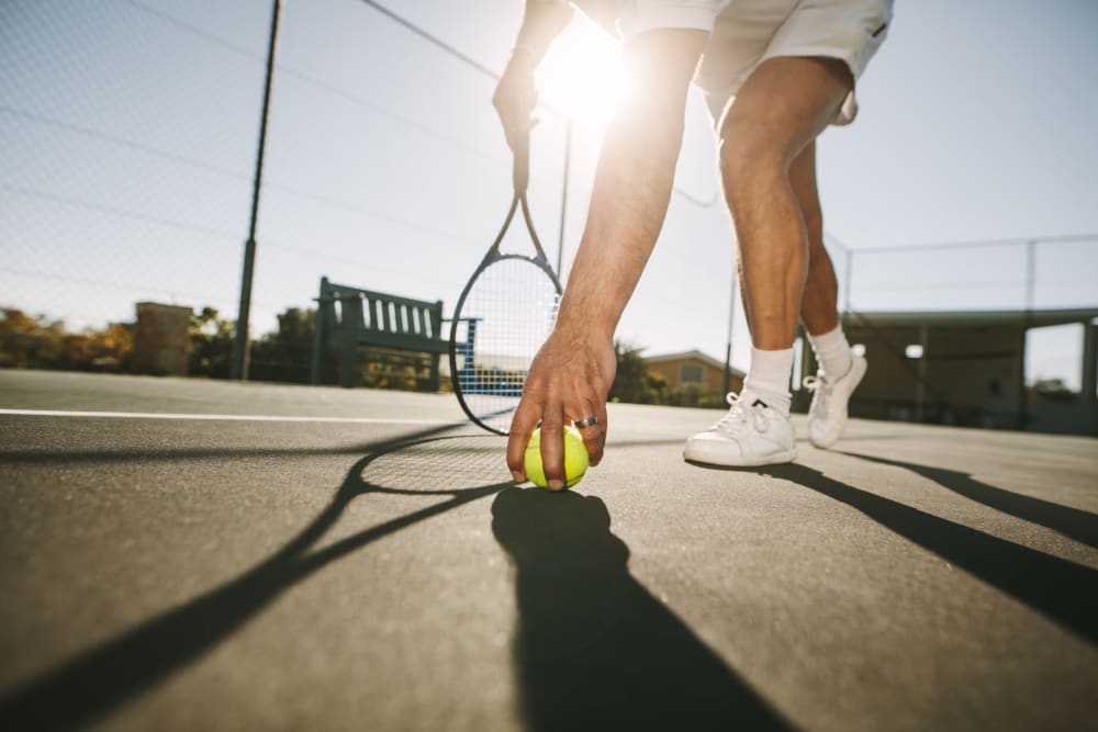 Resident playing tennis at Village on the Park Oklahoma City in Oklahoma City, Oklahoma