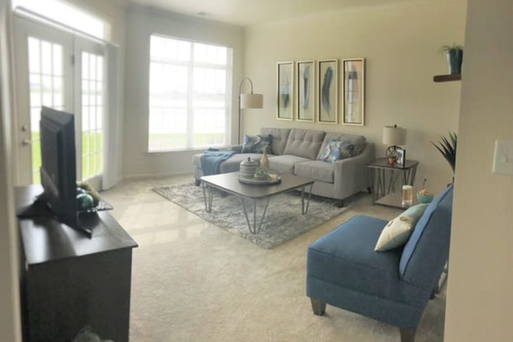 Resident living space with couches and access to balcony at Lakeshore Apartment Homes in Evansville, Indiana