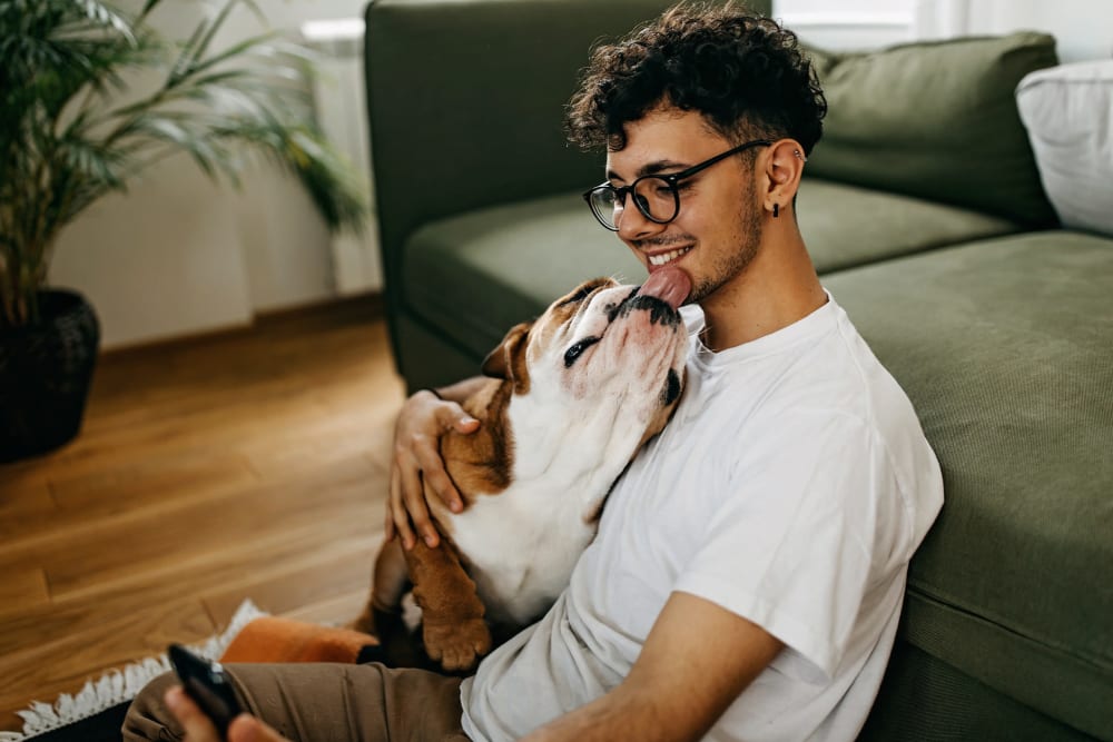 Man chilling with his dog in his apartment at The Courtyards in Edgewater Park, New Jersey