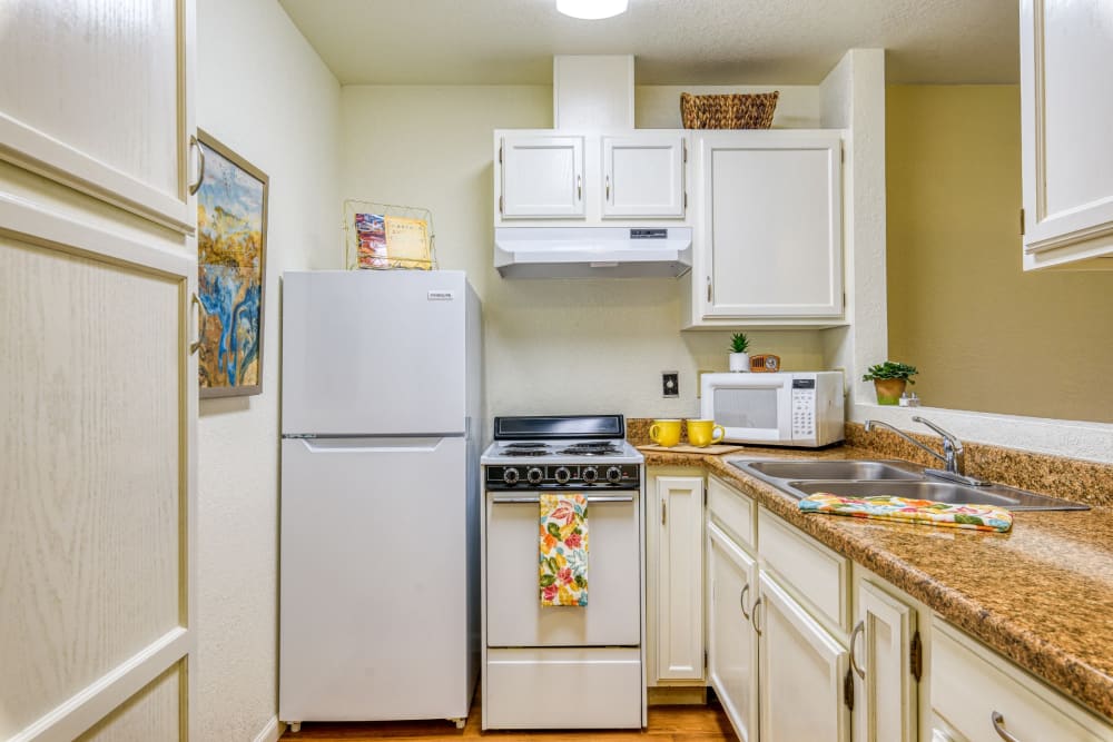 Resident kitchen with fridge, stove, and countertops at Pacifica Senior Living Fresno in Fresno, California