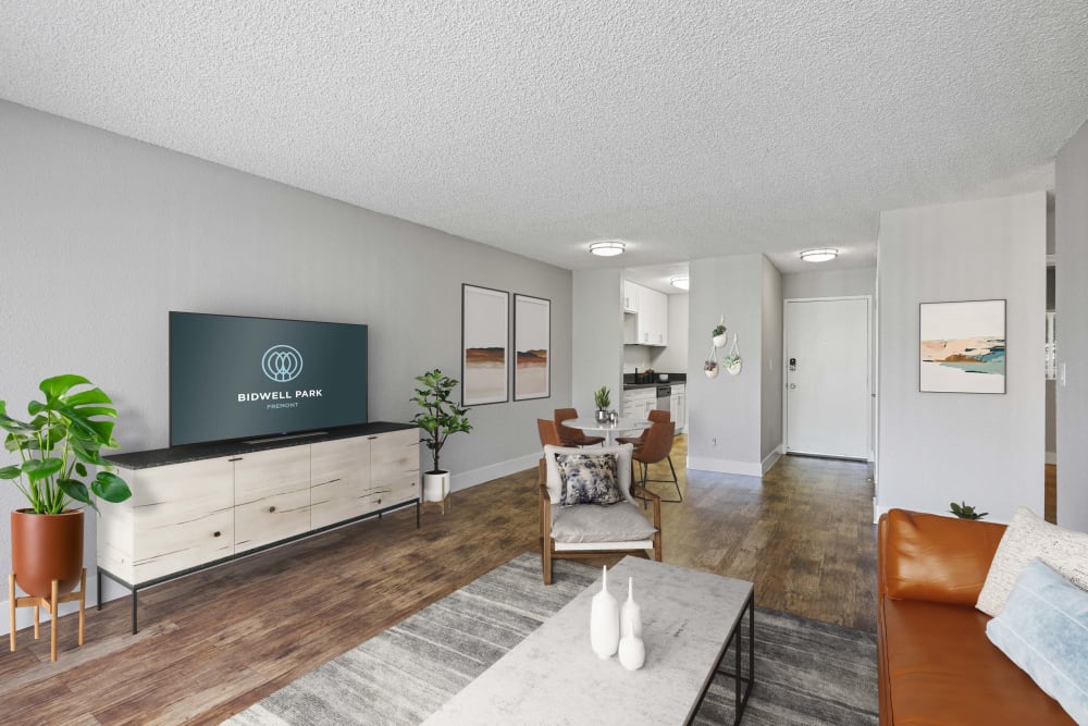 Spacious move-in ready living room with hardwood style flooring at Bidwell Park Fremont in Fremont, California