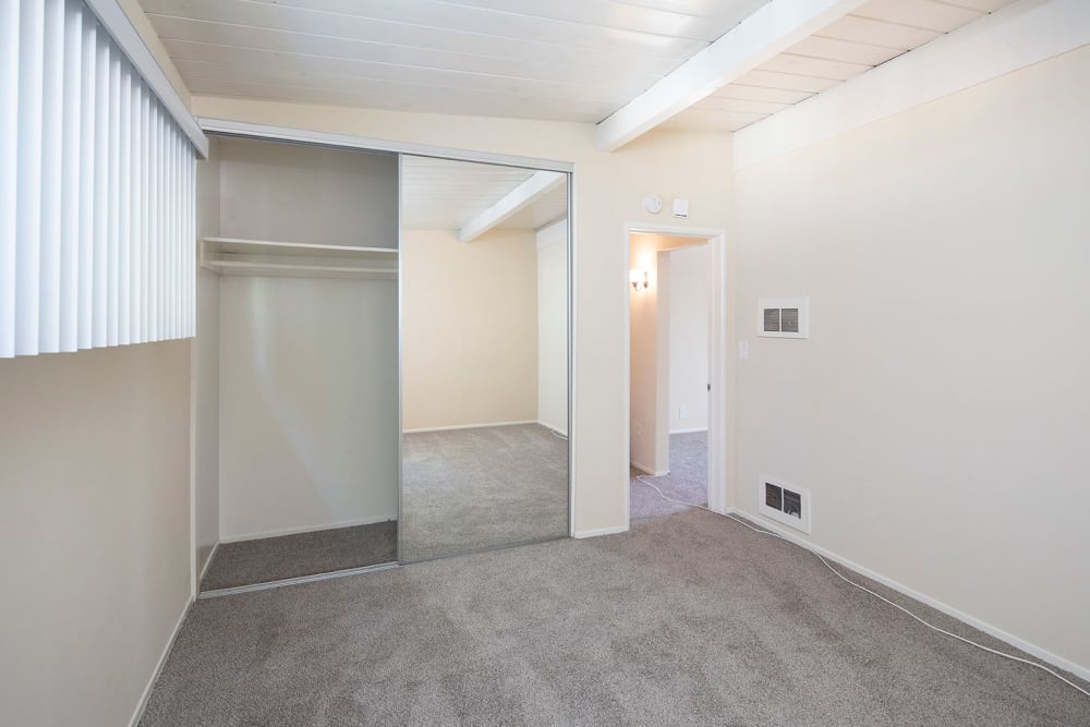 Carpeted room with mirrored closet doors at Sail Bay Apartments in San Diego, California 