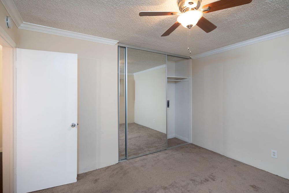 Model apartment with carpet and mirrored closet doors at Sail Bay Apartments in San Diego, California