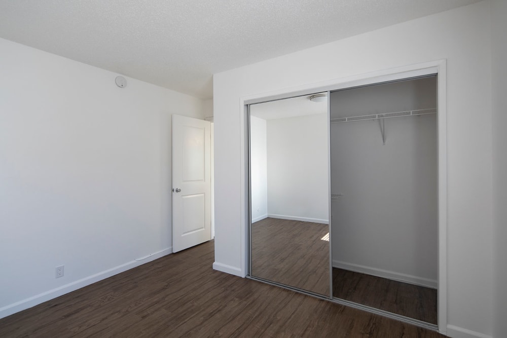 Bedroom with mirrored closet doors at Villas at Carlsbad in Carlsbad, California