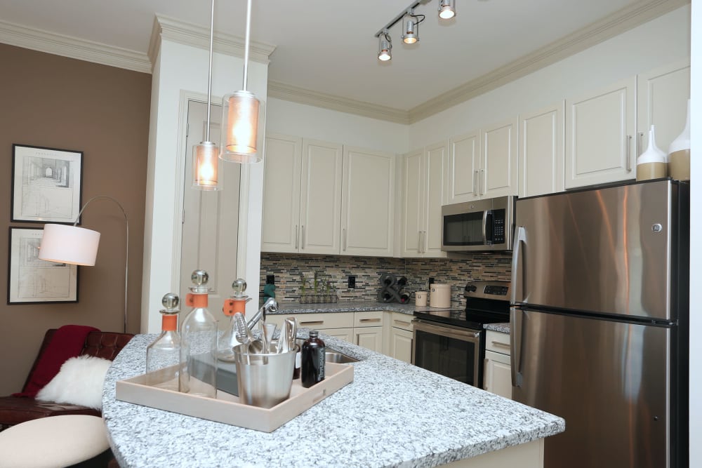 Stainless-steel appliances and an island in a model apartment's kitchen at 2370 Main at Sugarloaf in Duluth, Georgia