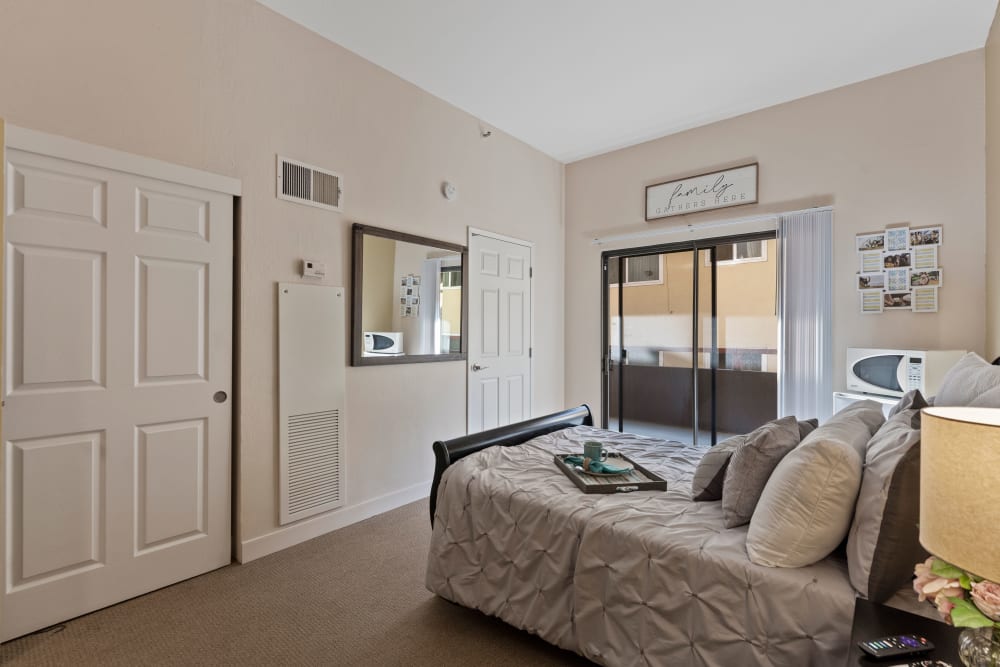Resident bedroom with closet and balcony access at Pacifica Senior Living Burlingame in Burlingame, California