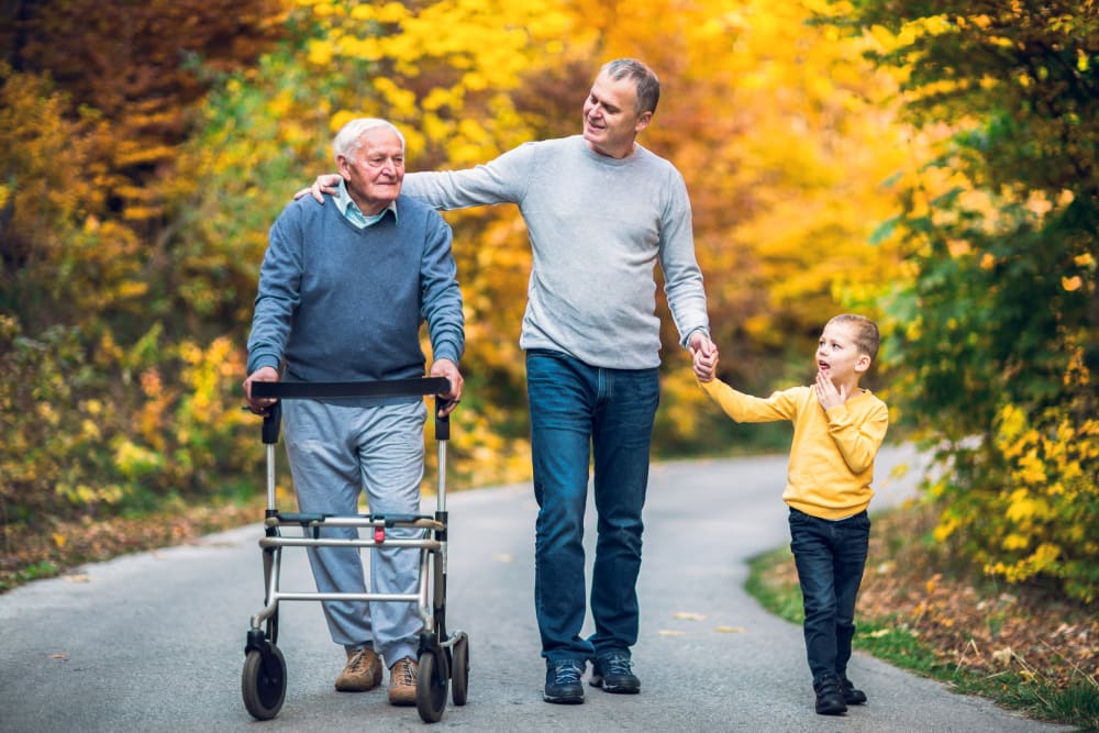 A resident on a walk with his son and grandchild at Heritage Meadows Gracious Retirement Living in Cambridge, Ontario