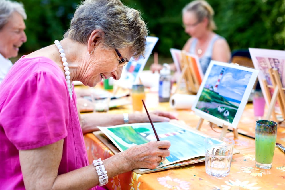 A group of residents painting outdoors at Heritage Meadows Gracious Retirement Living in Cambridge, Ontario