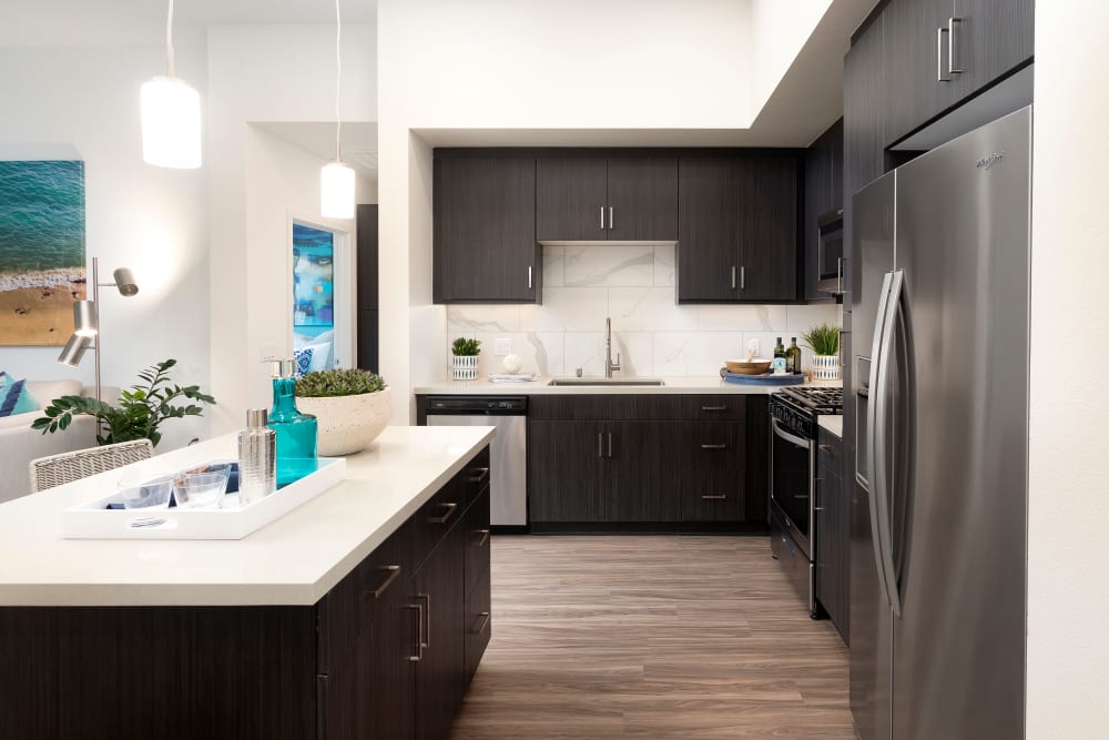 Modern kitchen space with wood-panel flooring at The Residences at Escaya in Chula Vista, California