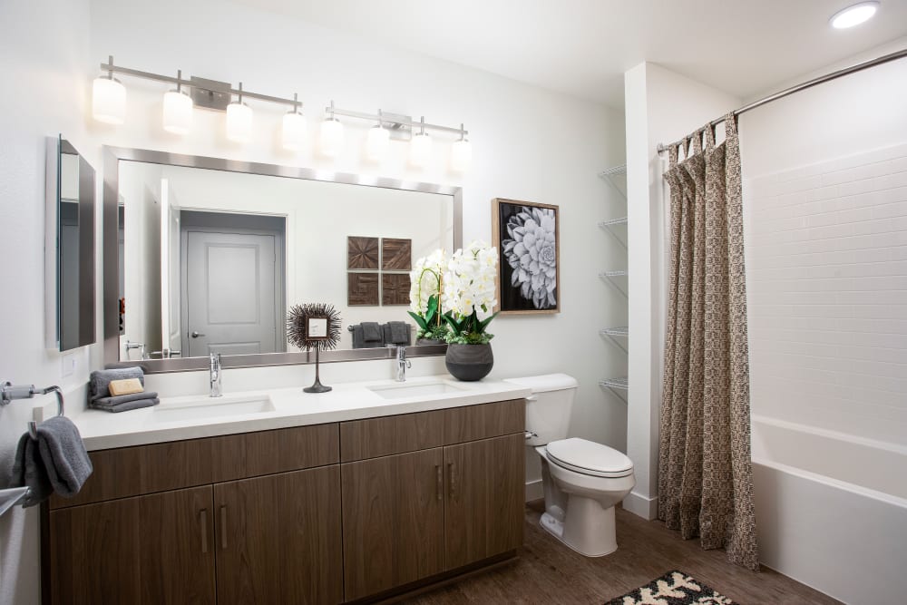 Model bathroom with brown cabinetry at The Residences at Escaya in Chula Vista, California