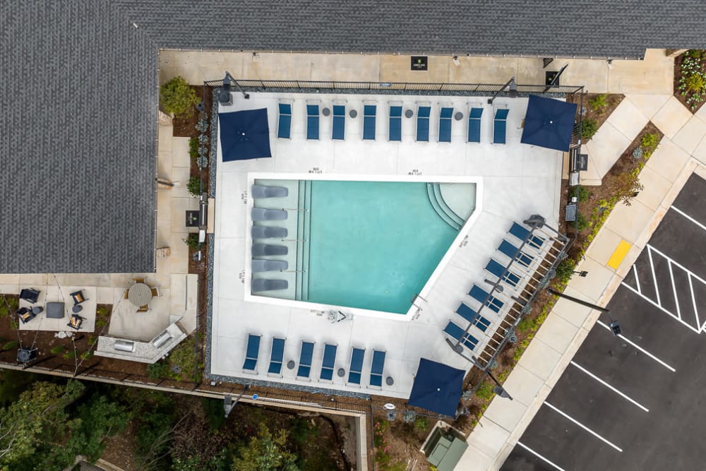 aerial view of exterior clubhouse with pool on sunny day