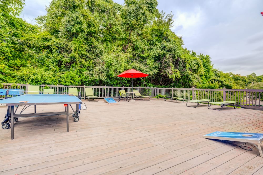 Pool deck with lounge chairs and a ping pong table at Hampton Greene Apartment Homes in Columbia, South Carolina