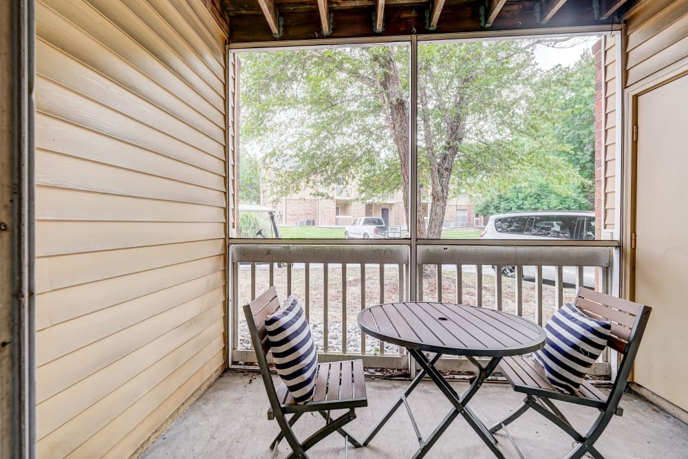 Balcony with a table and two chairs at Hampton Greene Apartment Homes in Columbia, South Carolina