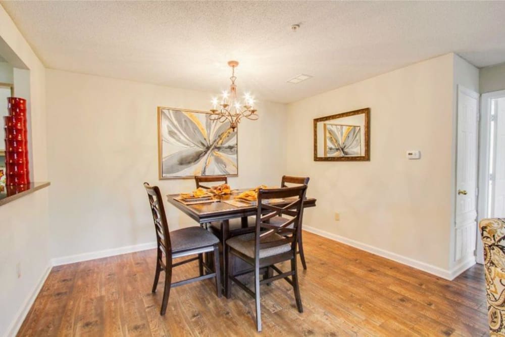 Wood flooring and a table with chairs in an apartment dining room at The Gables in Ridgeland, Mississippi