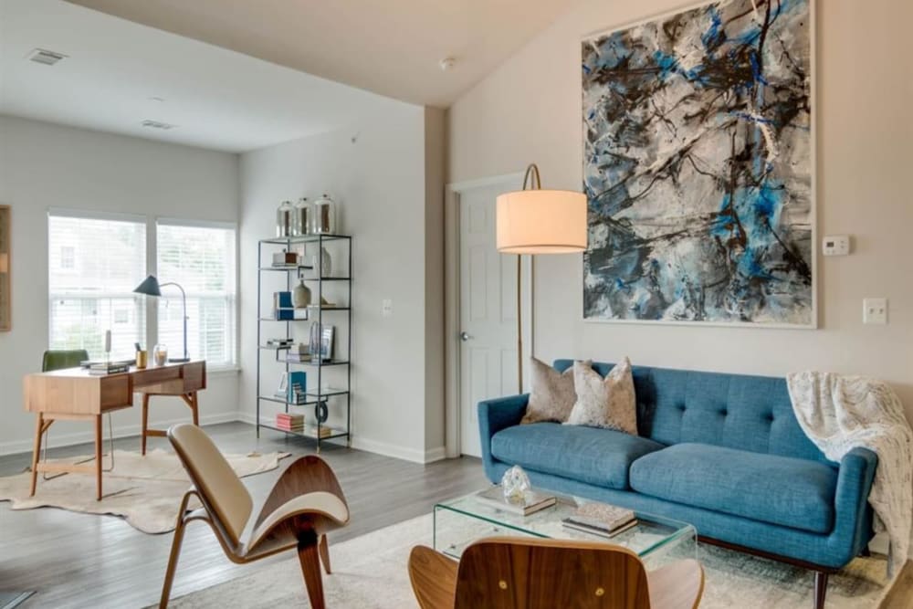 A warm inviting living room with a home office space at Park at Kingsview Village in Germantown, Maryland