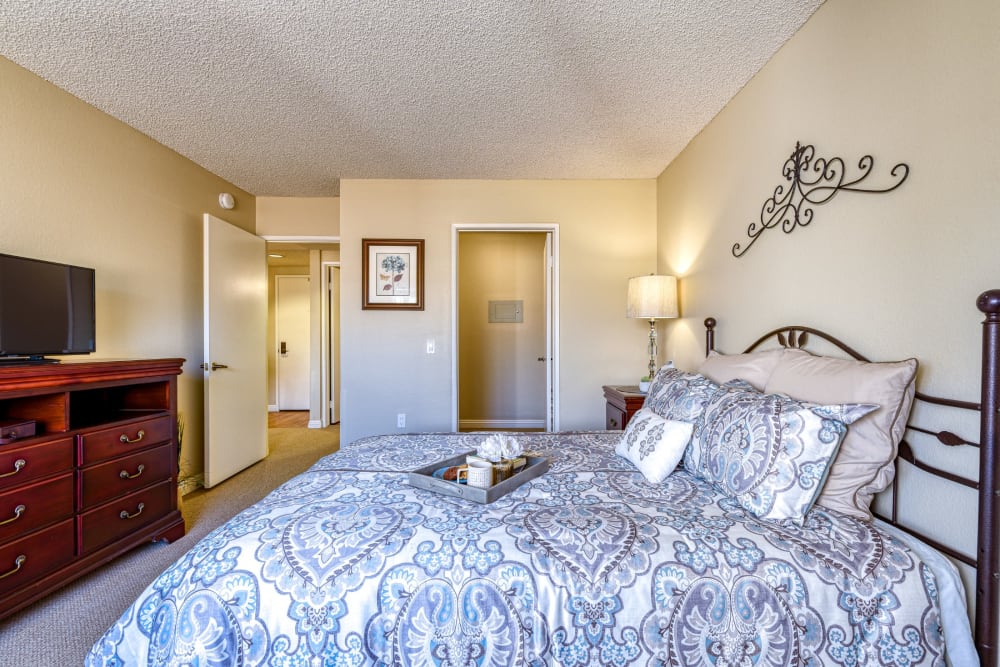 Resident bedroom with large dresser and tv at Pacifica Senior Living Menifee in Sun City, California