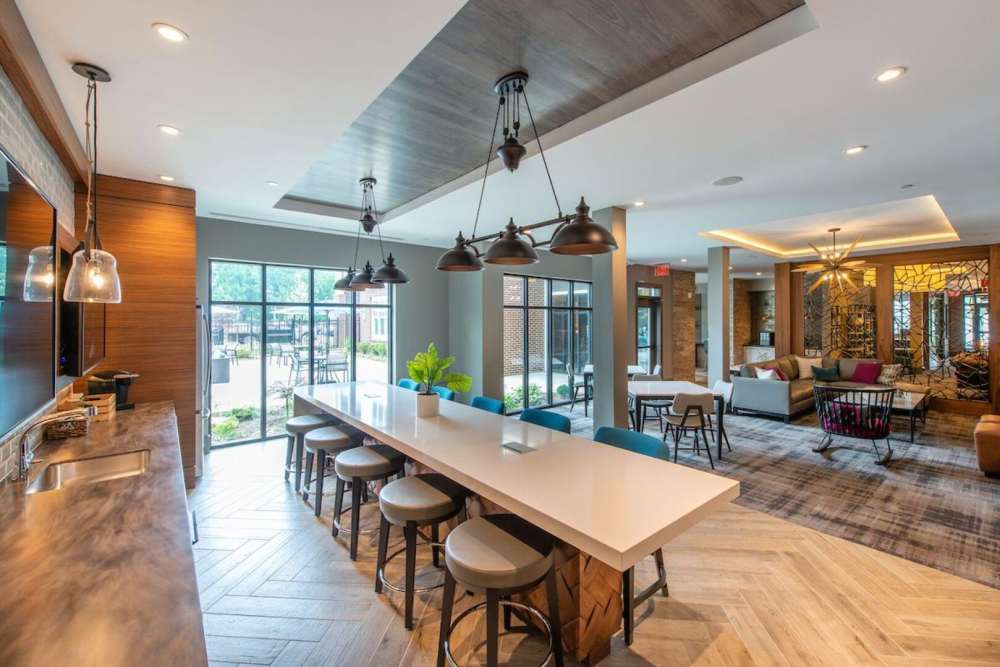 Club house dining room with pendent lights and access to outside seating area through a glass door at The Elms at Century in Germantown, Maryland