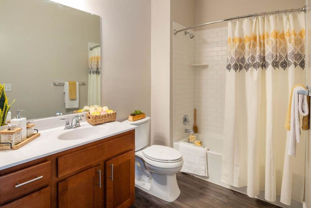 Bathroom with a tub, western style commode and storage space at The Elms at Century in Germantown, Maryland
