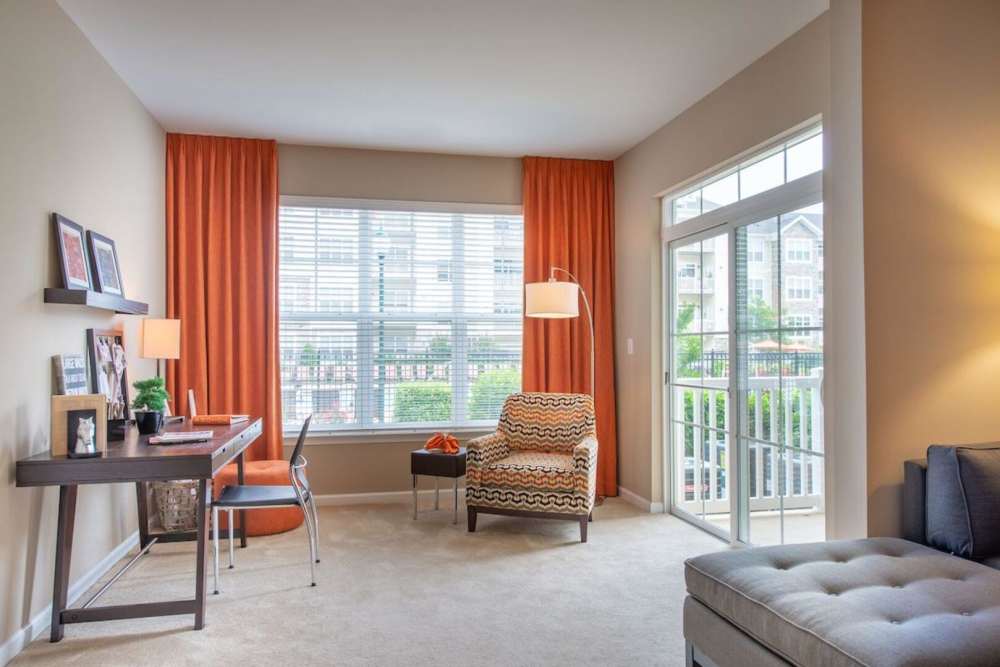 Living room with access to balcony at The Elms at Clarksburg Village in Clarksburg, Maryland
