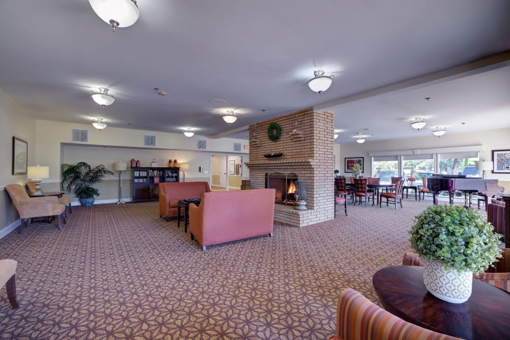 Lounge area with fireplace and couches at Pacifica Senior Living Encinitas in Encinitas, California
