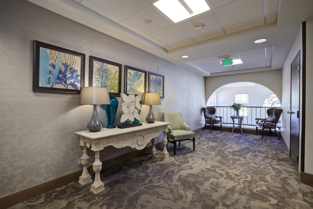 Carpeted hallway with large decorative table at Pacifica Senior Living Rancho Peñasquitos in San Diego, California