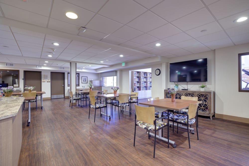 Resident dining area with large television on the wall at Pacifica Senior Living Rancho Peñasquitos in San Diego, California