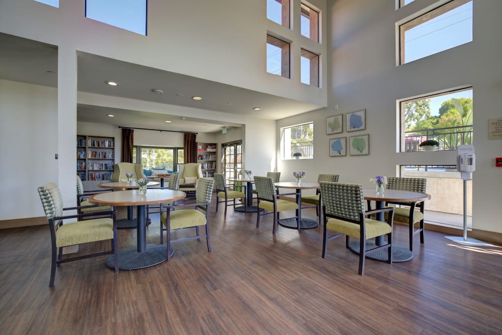 Dining area with seating and multiple windows at Pacifica Senior Living Rancho Peñasquitos in San Diego, California