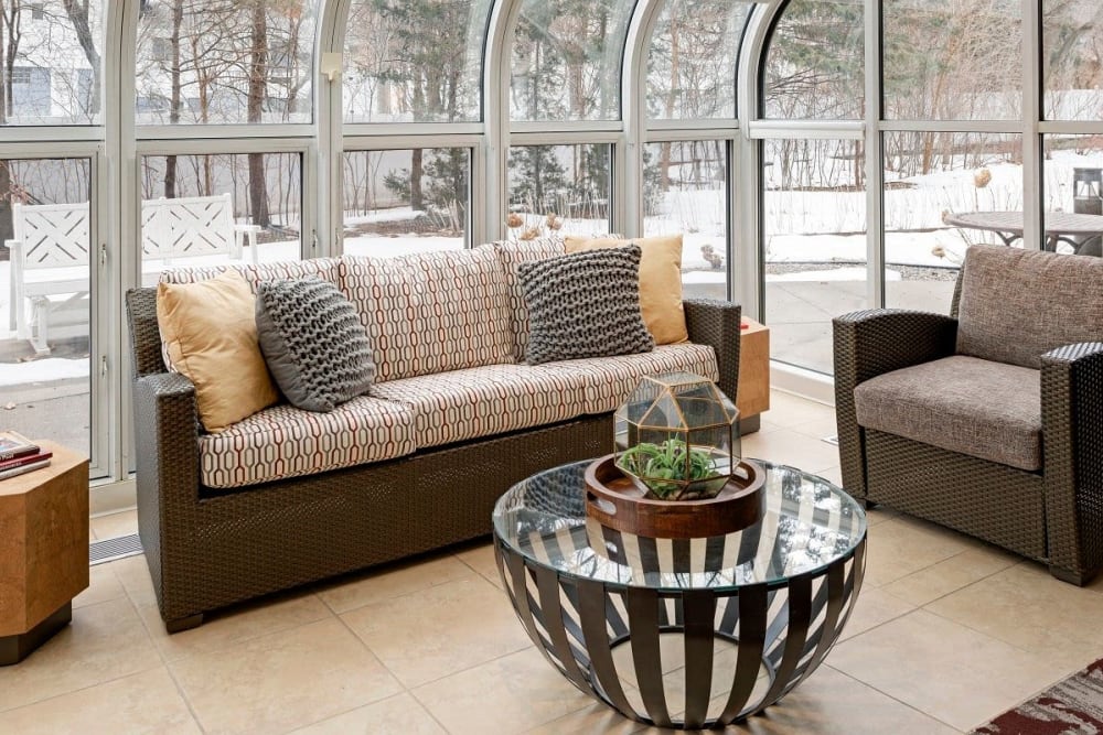 Resident seating area with couches, chair, and round coffee table at Vernon Terrace of Edina in Edina, Minnesota