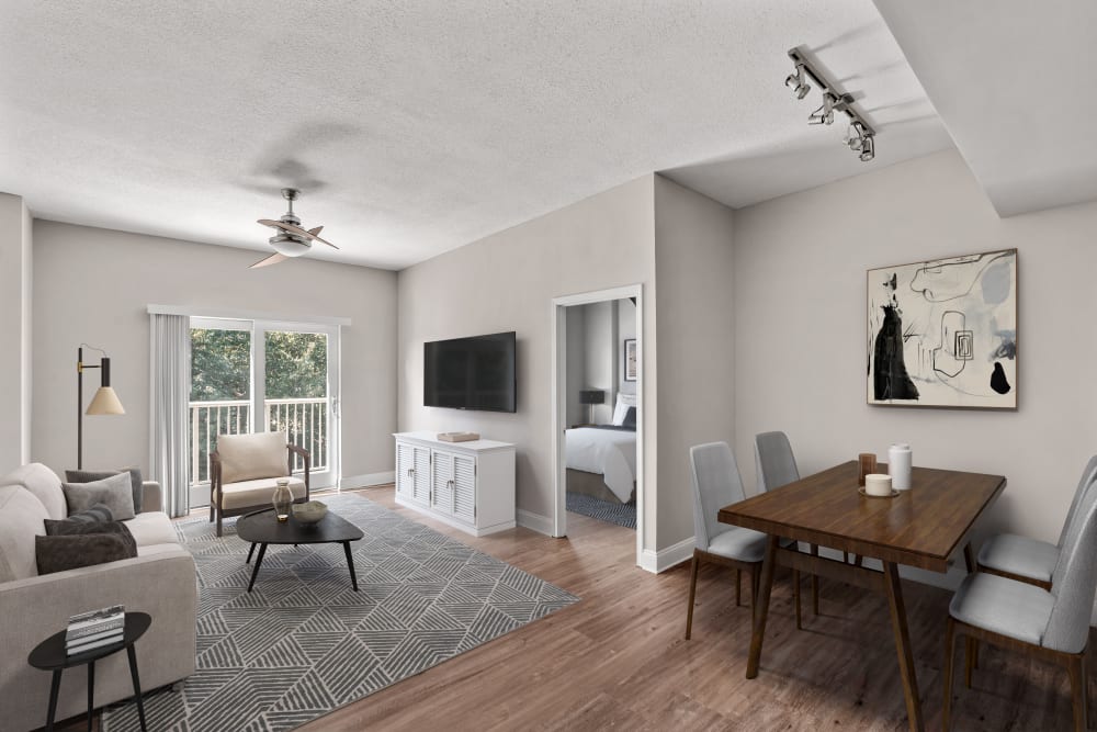 Open concept living and dining area with contemporary plank flooring and a ceiling fan in a model home at SouthPark Morrison in Charlotte, North Carolina