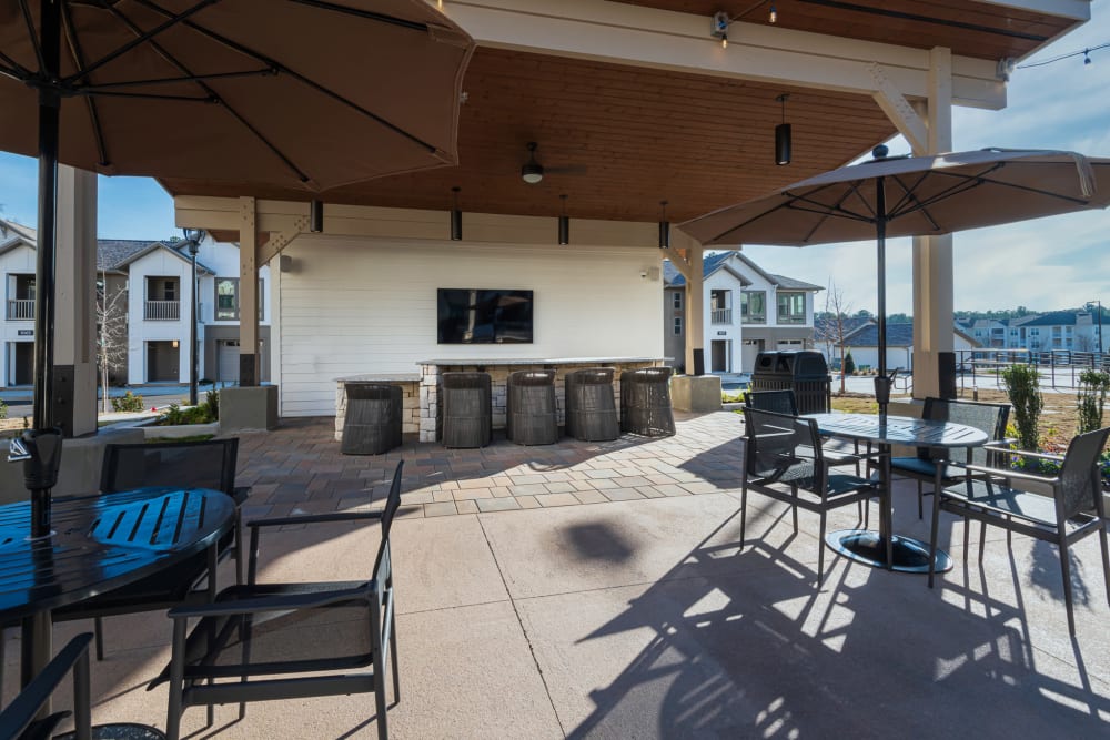 Outdoor lounge with patio seating and a bar and TV at The Reserve at Patterson Place in Durham, North Carolina