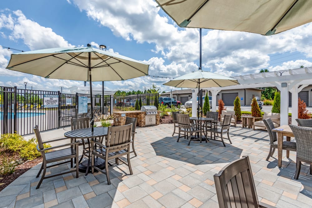 Extensive poolside seating area with umbrellas at Flats At 540 in Apex, North Carolina