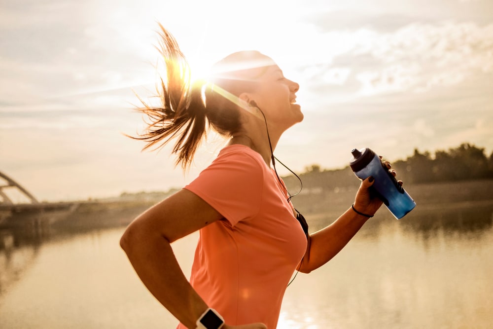 Woman running with the sun rising behind her, near Laurel Ridge in Hillsville, Virginia