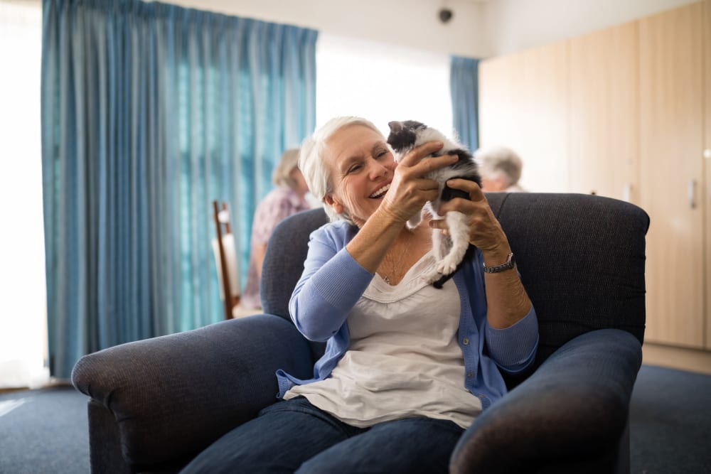 Senior woman holds her pet kitten in New Shiloh Village Senior Apartments in Baltimore, Maryland