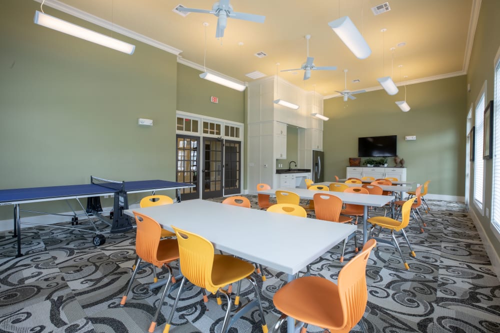 A ping pong table and seating at tables in the community clubhouse at Cypress Creek Wayside Drive in Houston, Texas