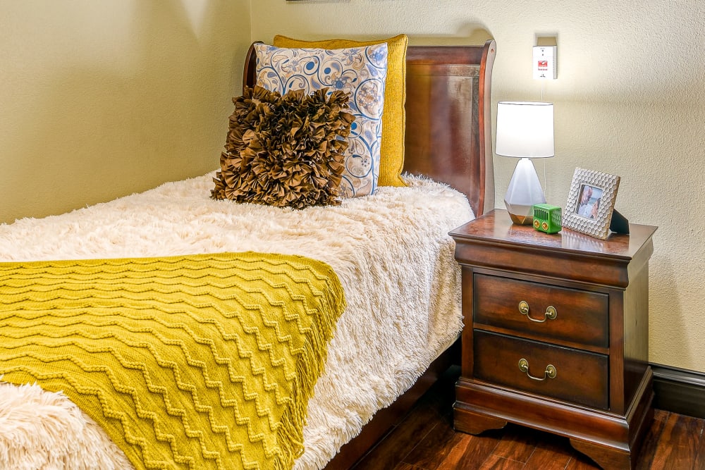 Single bed at Pacifica Senior Living San Martin in Las Vegas, Nevada with wooden side cabinet 