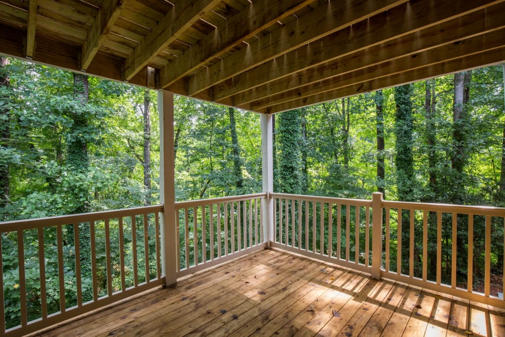 Covered wooden balcony with a gorgeous view at The Crossing at Henderson Mill Apartment Homes in Atlanta, Georgia