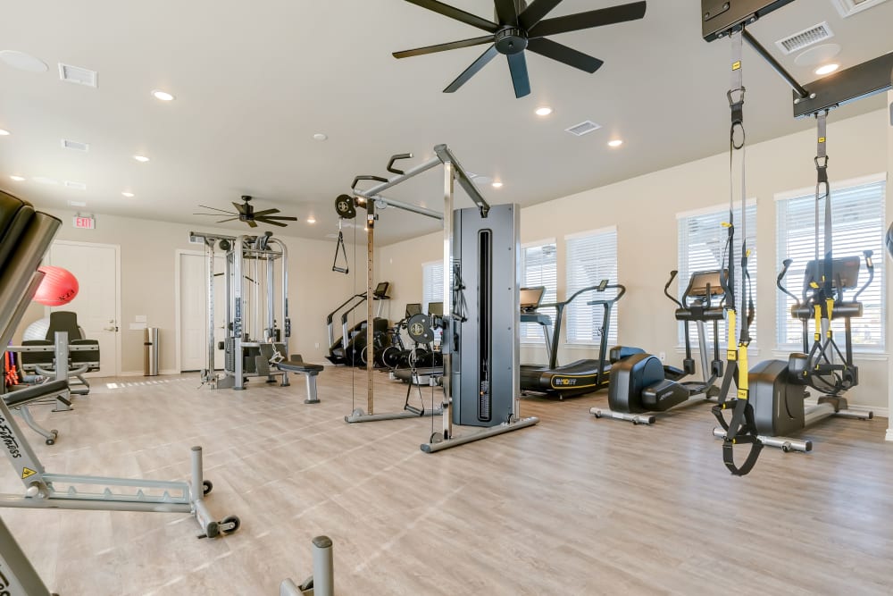 Full sized resident fitness center with all the machines and free weights you could need for a solid workout at BB Living Light Farms in Celina, Texas