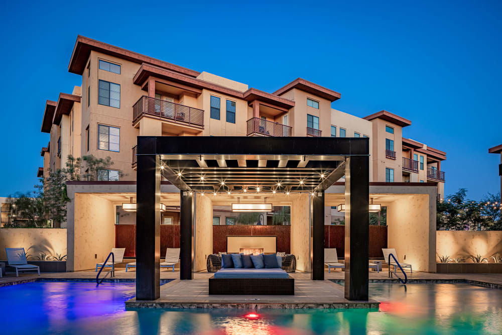 Outdoor lounge seating surrounded by pool at Marquis at Desert Ridge in Phoenix, Arizona