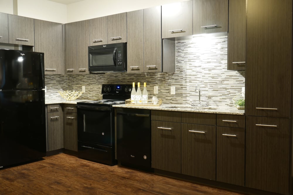 Kitchen with black appliances at Terra at University North Park in Norman, Oklahoma