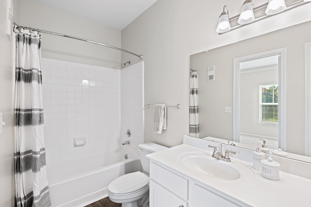 Bright bathroom with white counters and cabinets at Marquis at Silverton in Cary, North Carolina
