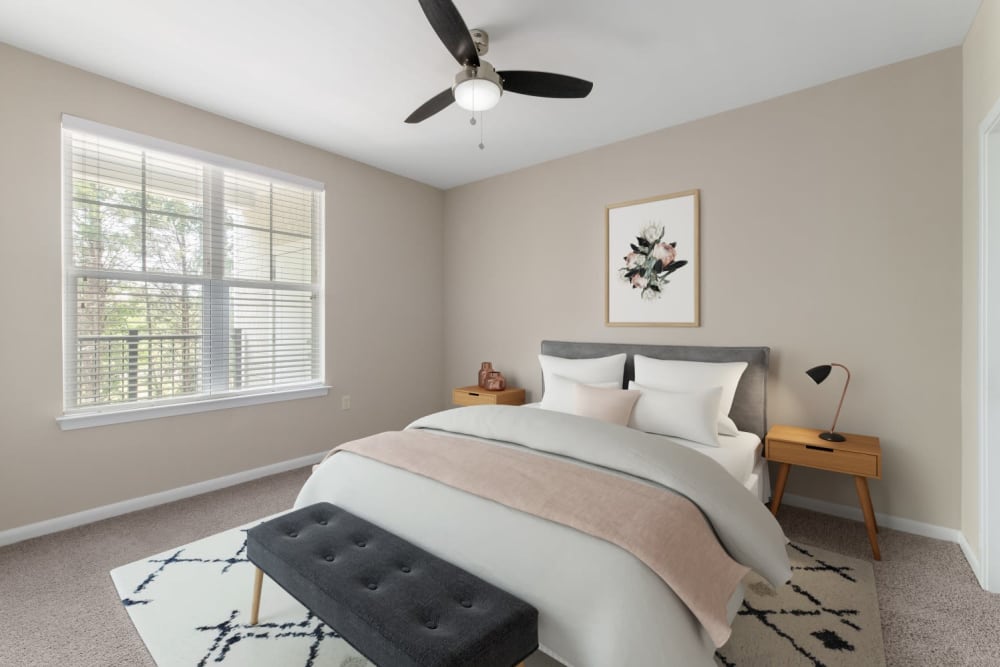 Plush carpeting and a ceiling fan in a model home's bedroom at The Palmer in Charlotte, North Carolina