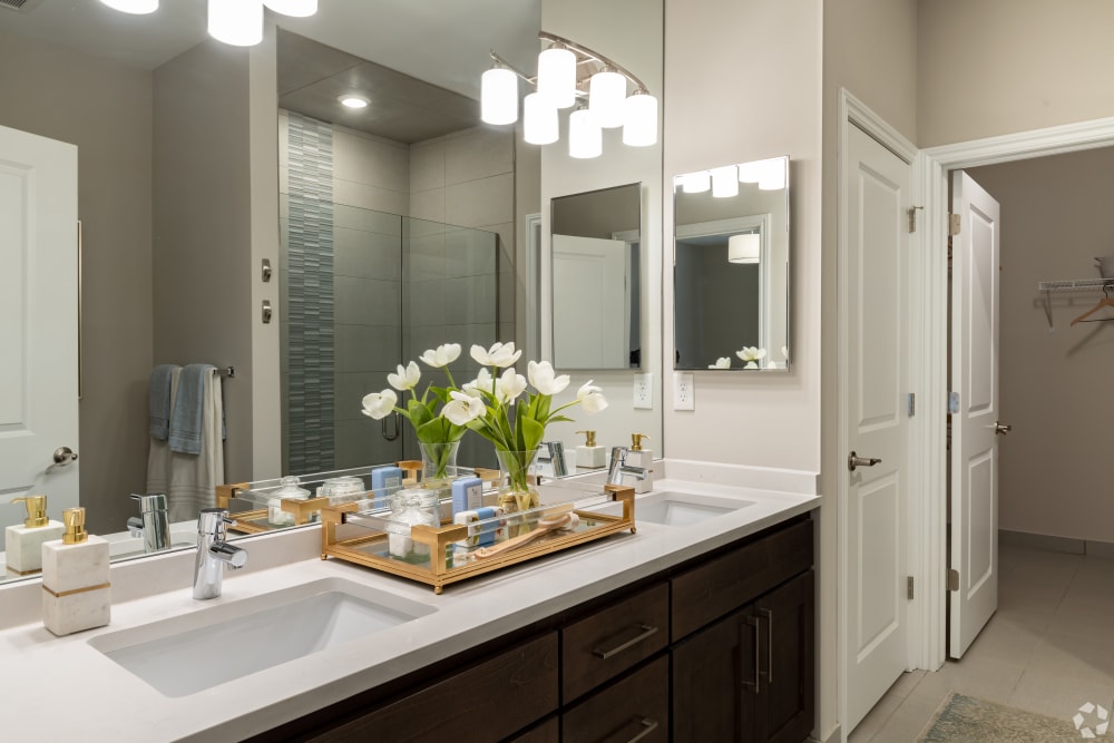 Bathroom with double sinks and granite countertops at Encore at Deerhill in Clarkston, Michigan