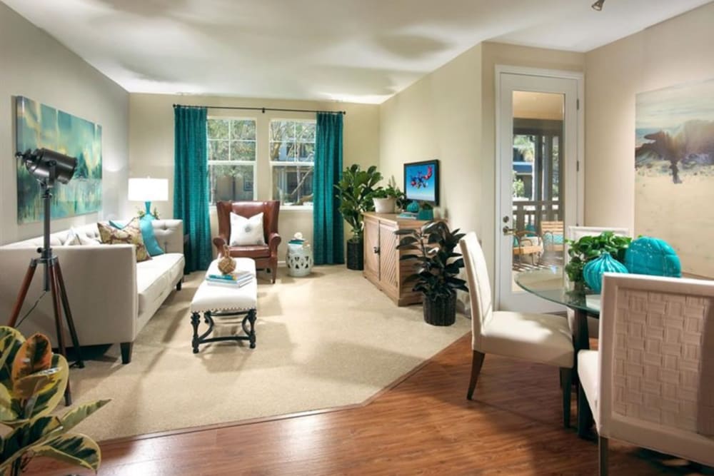Carpeted living room with large windows at Artisan at East Village Apartments in Oxnard, California