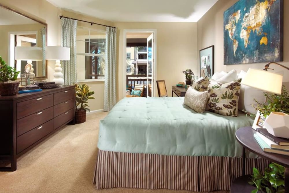 Apartment bedroom with large bed and dresser at Artisan at East Village Apartments in Oxnard, California