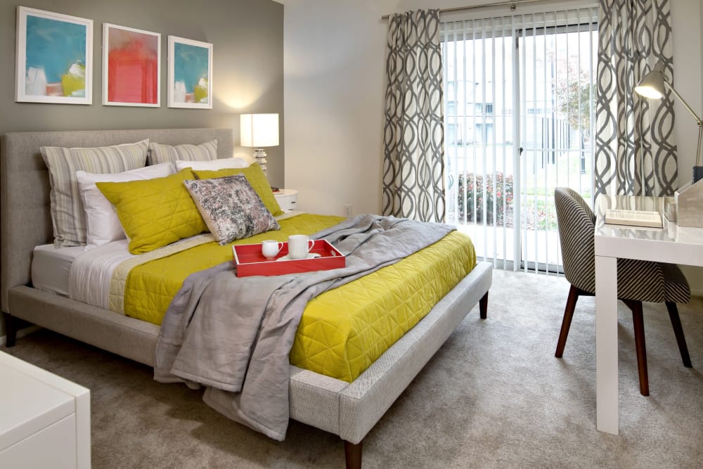 Apartment bedroom with hardwood floors and sliding exterior door at Artisan at Lawrenceville in Lawrenceville, New Jersey