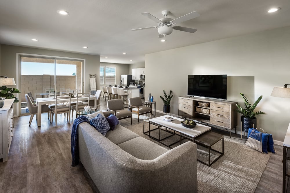 Model living room with TV in a well lit home at Las Casas at Windrose in Litchfield Park, Arizona